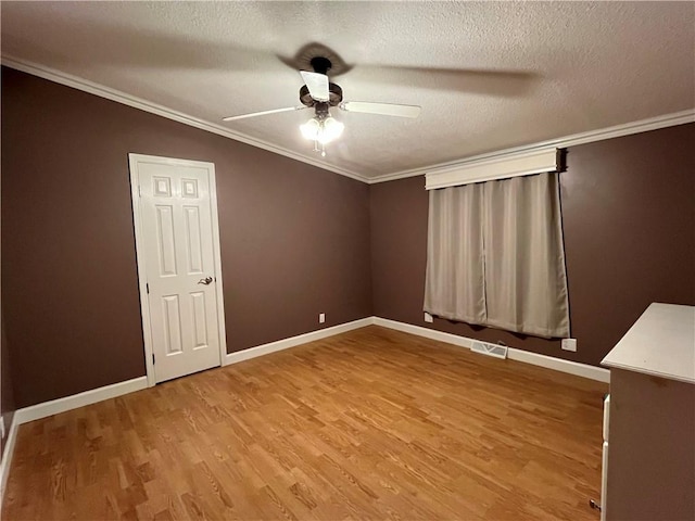 unfurnished bedroom with lofted ceiling, ceiling fan, ornamental molding, a textured ceiling, and wood-type flooring