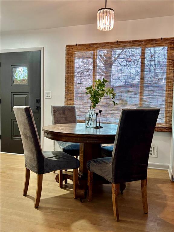 dining room featuring a wealth of natural light, visible vents, light wood-type flooring, and baseboards