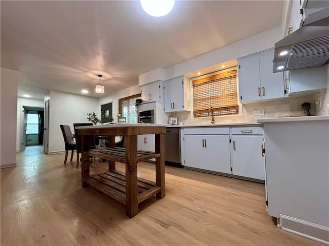 kitchen featuring light hardwood / wood-style floors, white cabinets, pendant lighting, and appliances with stainless steel finishes