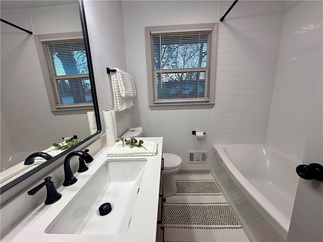 full bathroom featuring tile patterned flooring, vanity, toilet, and tiled shower / bath combo