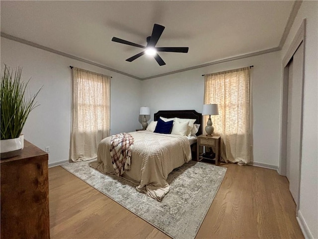 bedroom featuring light hardwood / wood-style floors, ceiling fan, and crown molding