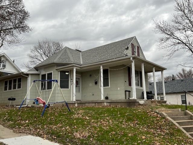 view of front of house featuring covered porch and a front yard