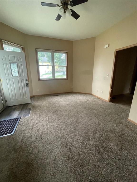 unfurnished living room featuring carpet floors and ceiling fan