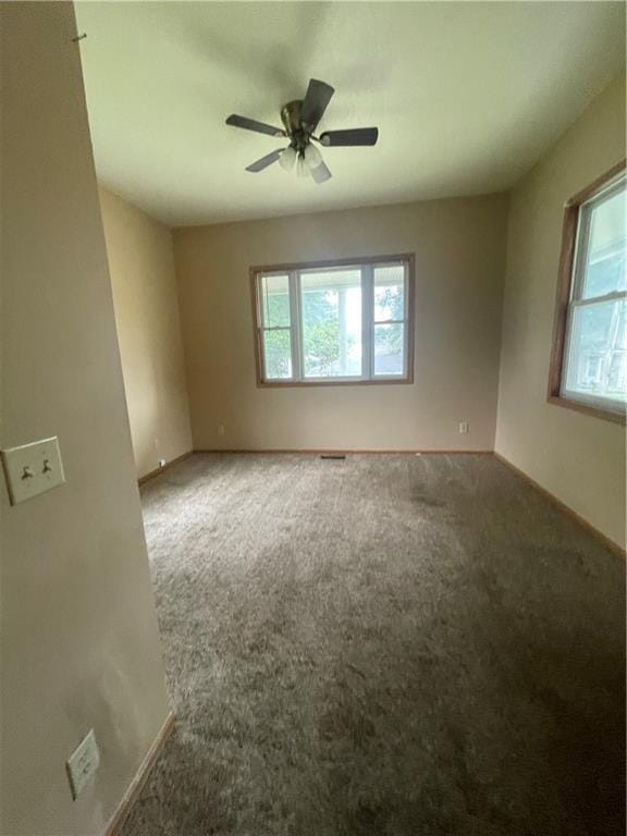 unfurnished room featuring carpet flooring, ceiling fan, and a healthy amount of sunlight