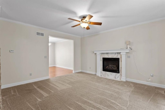 unfurnished living room with crown molding, carpet floors, a fireplace, and ceiling fan