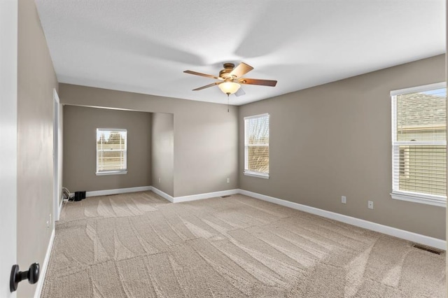 spare room featuring light colored carpet and ceiling fan