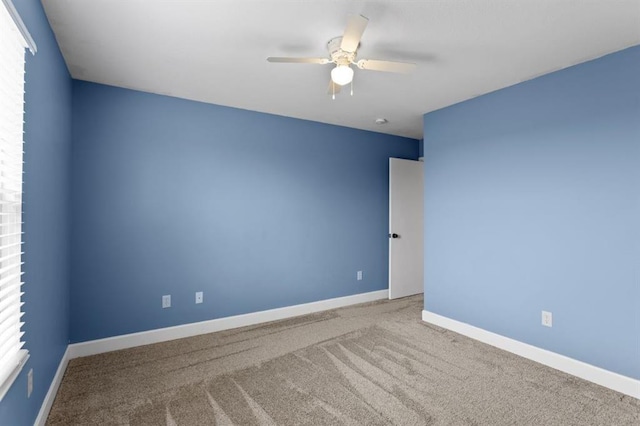 spare room with ceiling fan and carpet