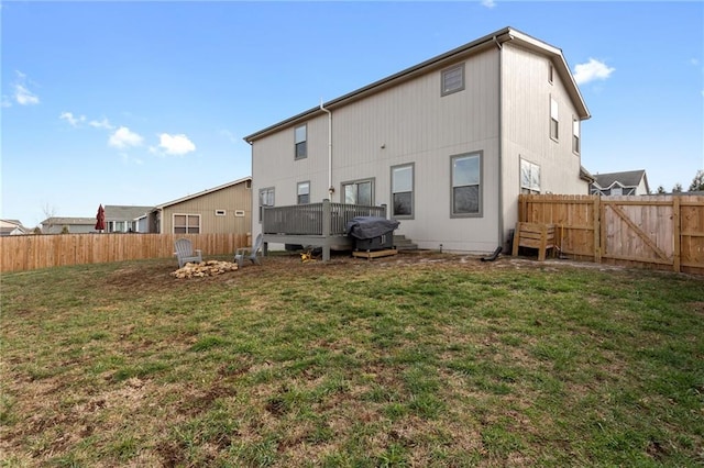 rear view of property with a wooden deck and a lawn