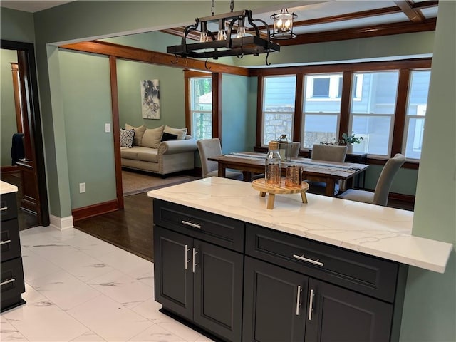 kitchen with a notable chandelier, light hardwood / wood-style floors, light stone countertops, and crown molding