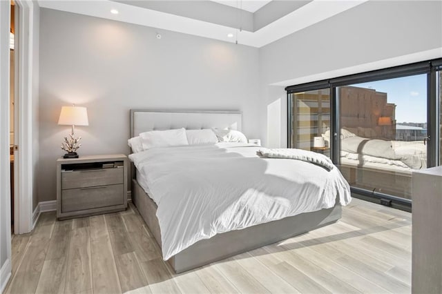 bedroom with a high ceiling and light wood-type flooring