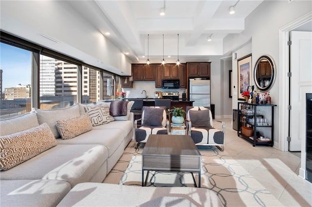 living room with beamed ceiling, light tile patterned floors, sink, and coffered ceiling