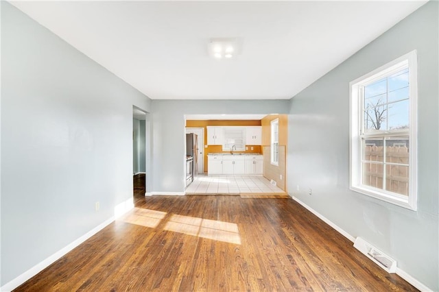 unfurnished living room featuring sink and light wood-type flooring