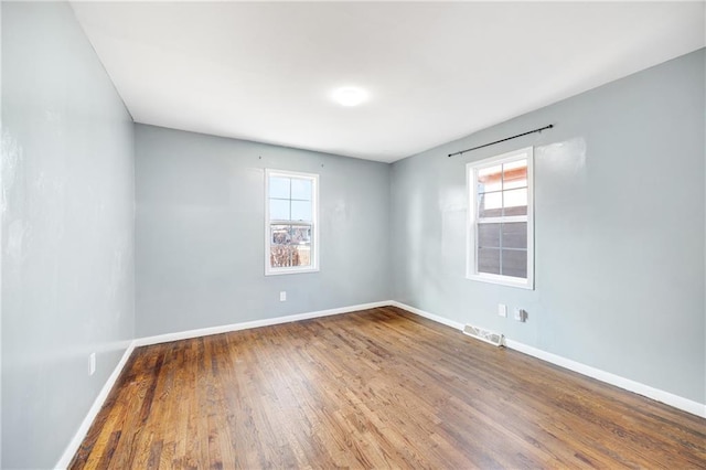 empty room featuring hardwood / wood-style flooring and a healthy amount of sunlight