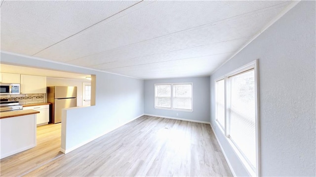 unfurnished living room featuring a textured ceiling and light wood-type flooring