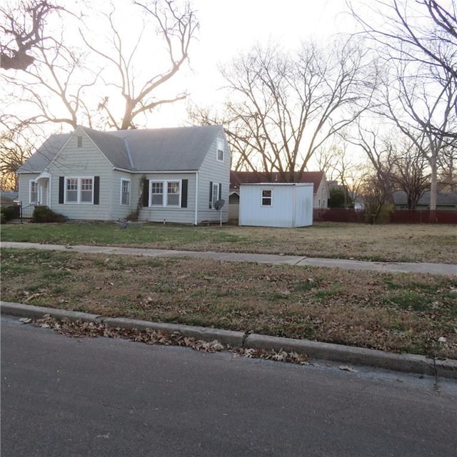 view of front of home featuring a front yard and a storage shed