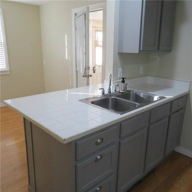 kitchen featuring dark hardwood / wood-style flooring, gray cabinetry, and sink