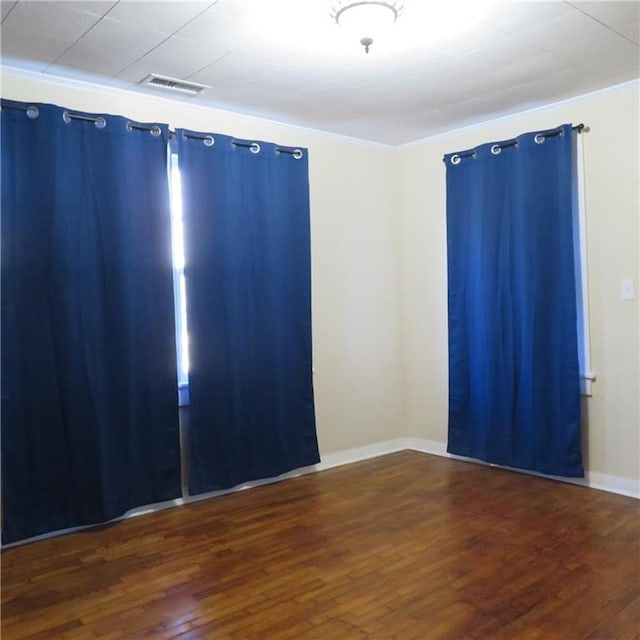 empty room featuring dark hardwood / wood-style floors and crown molding