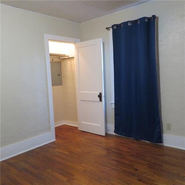 spare room with dark hardwood / wood-style floors and electric panel