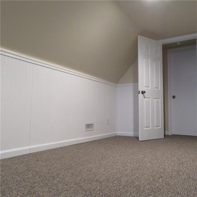 additional living space featuring carpet flooring and lofted ceiling