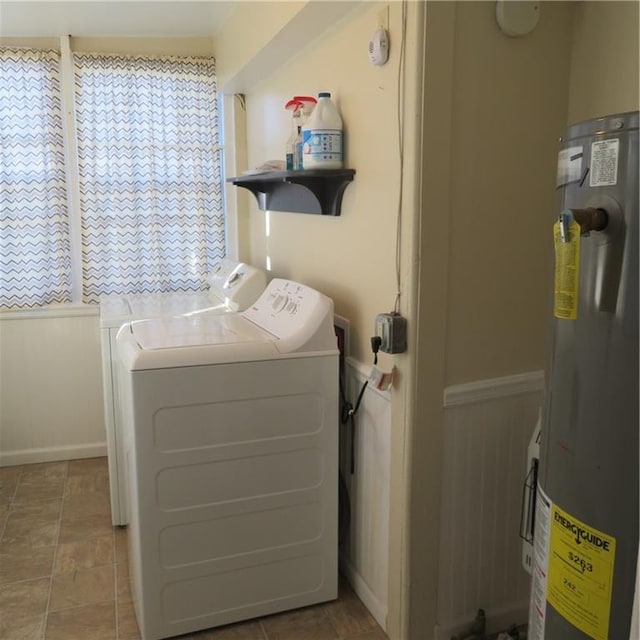 clothes washing area featuring electric water heater and washer and clothes dryer