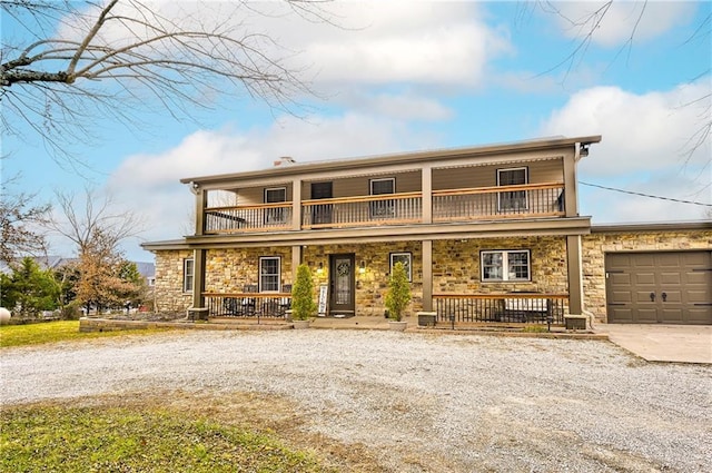 front of property featuring a porch, a balcony, and a garage