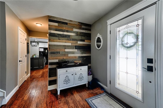 foyer entrance featuring dark wood-type flooring and wood walls