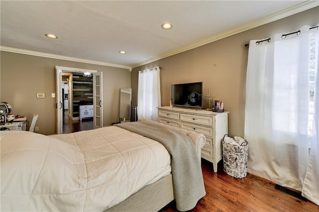 bedroom with ornamental molding and dark hardwood / wood-style floors