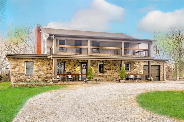 front of property featuring a garage, a balcony, and covered porch