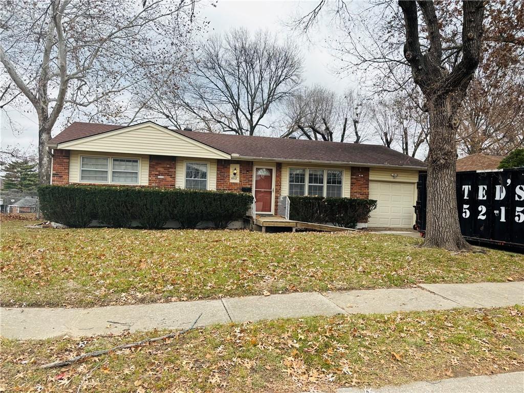 ranch-style house featuring a front lawn and a garage