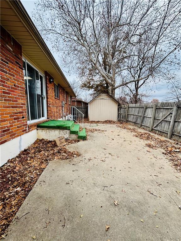 view of yard featuring a patio and a storage shed