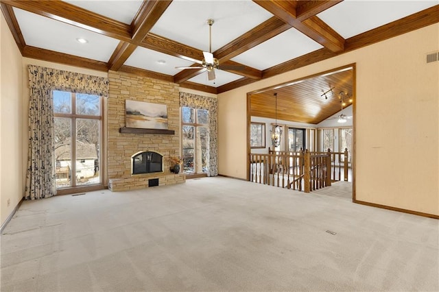 unfurnished living room featuring coffered ceiling, a healthy amount of sunlight, a fireplace, and light carpet