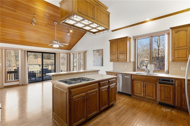 kitchen with sink, appliances with stainless steel finishes, a center island, tasteful backsplash, and wooden ceiling