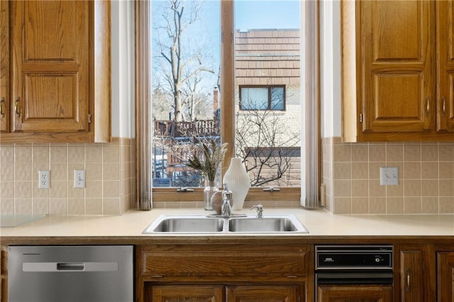 kitchen featuring sink, stainless steel dishwasher, and backsplash