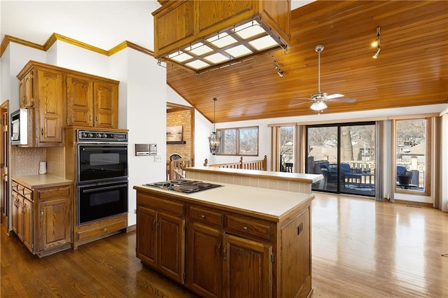 kitchen with pendant lighting, decorative backsplash, appliances with stainless steel finishes, and a kitchen island