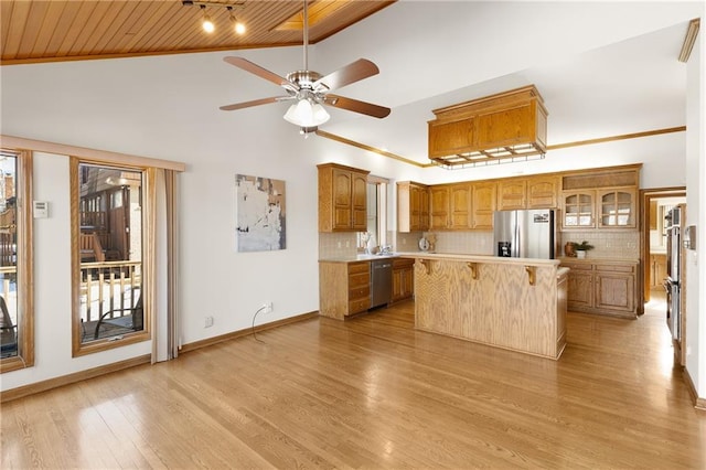 kitchen with a kitchen bar, tasteful backsplash, wooden ceiling, appliances with stainless steel finishes, and a kitchen island