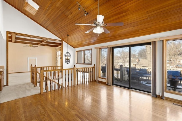 unfurnished room featuring a skylight, ceiling fan, wood ceiling, and light hardwood / wood-style floors