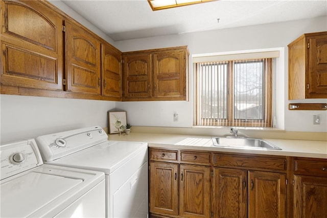 clothes washing area with cabinets, washer and dryer, and sink