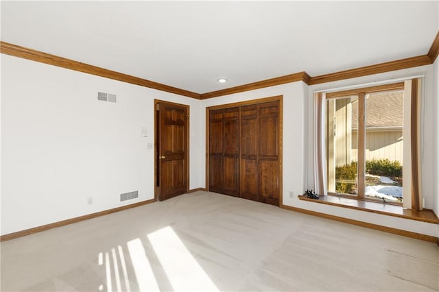 unfurnished bedroom with ornamental molding, light colored carpet, and a closet