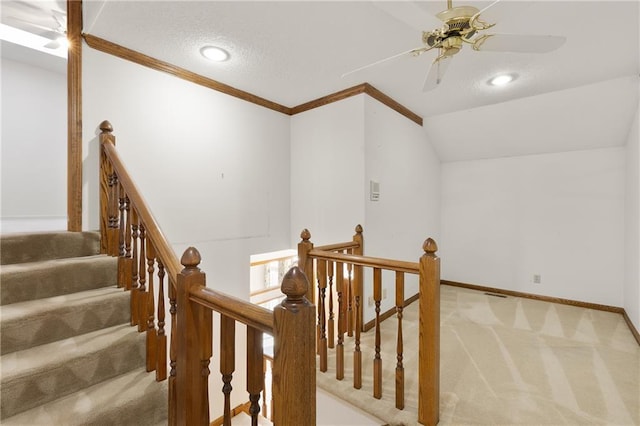 stairway featuring vaulted ceiling, carpet flooring, crown molding, and a textured ceiling