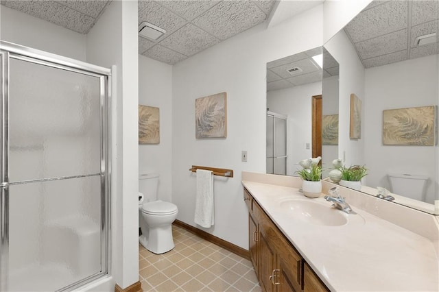 bathroom with a drop ceiling, toilet, and walk in shower