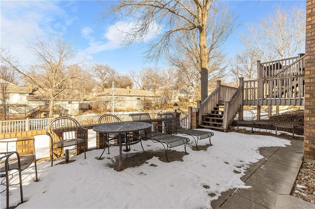 snow covered patio featuring a wooden deck