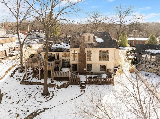 snow covered property with a wooden deck