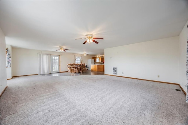 unfurnished living room with carpet and ceiling fan