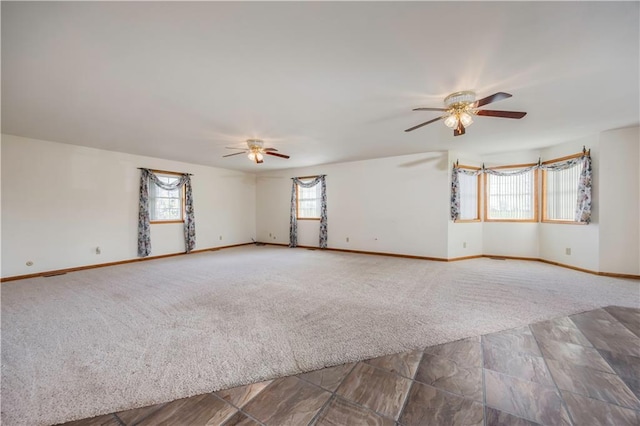 carpeted spare room featuring ceiling fan