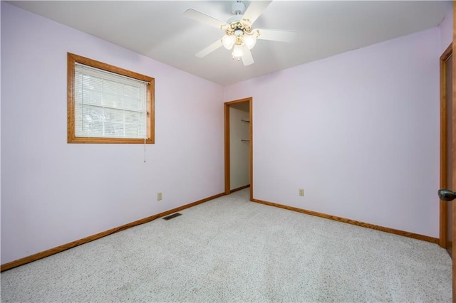 carpeted spare room with ceiling fan