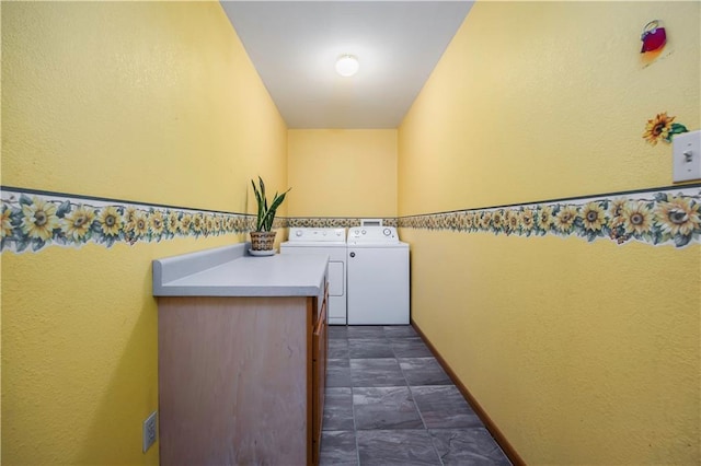 clothes washing area with washer and dryer and cabinets