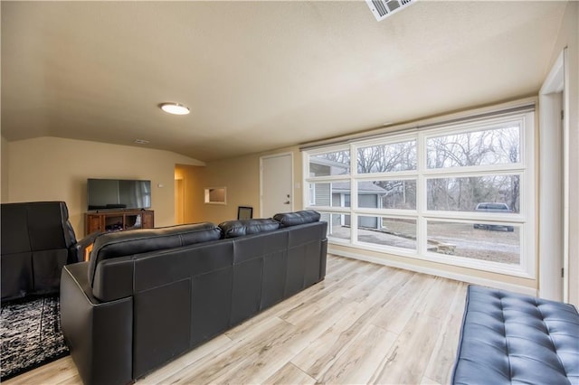 living room with light hardwood / wood-style flooring and vaulted ceiling