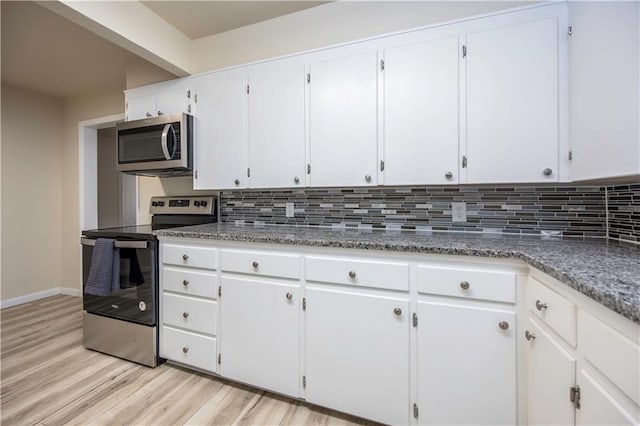 kitchen featuring tasteful backsplash, white cabinets, stainless steel appliances, and light wood-type flooring