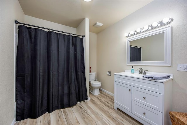 bathroom featuring hardwood / wood-style floors, vanity, and toilet