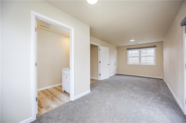 unfurnished bedroom featuring light carpet